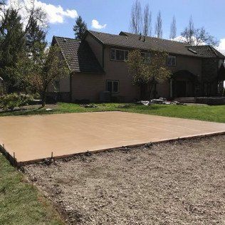 A large concrete slab is sitting in front of a large house.
