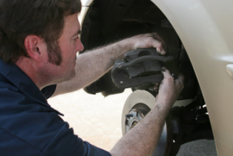 Cheyenne automobile mechanic changing brake pads at clients house.
