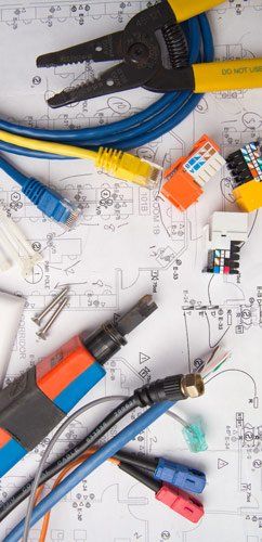 A bunch of electrical tools are laying on top of a drawing.