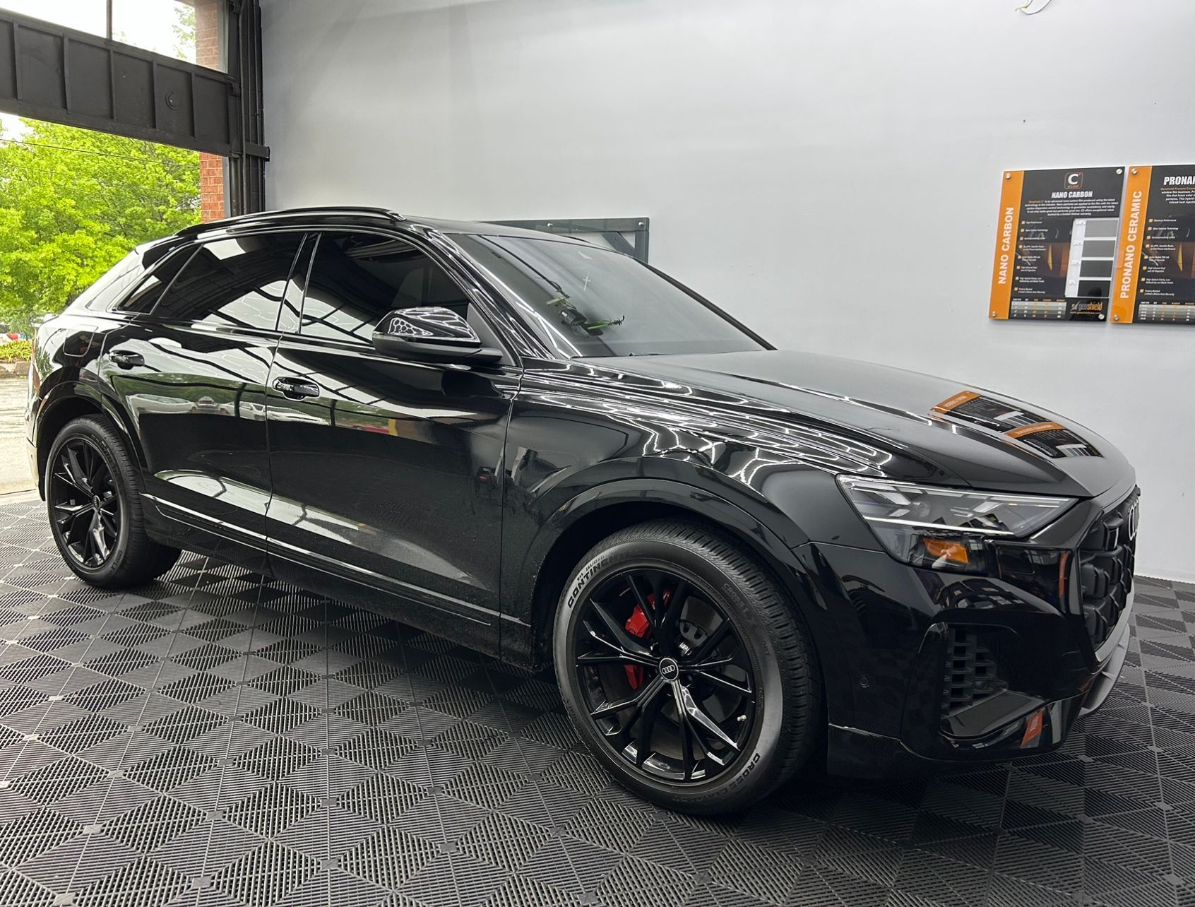 A black audi q8 is parked in a garage.