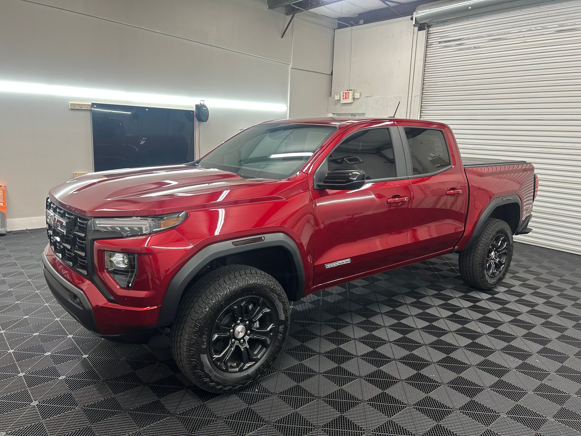 A red pickup truck is parked in a garage.
