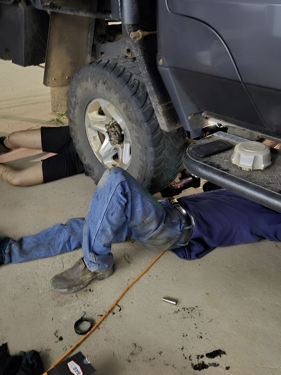 A Man is Laying on the Ground Under a Vehicle — SMK Rural & Mechanical Pty Ltd in Rockhampton City, QLD