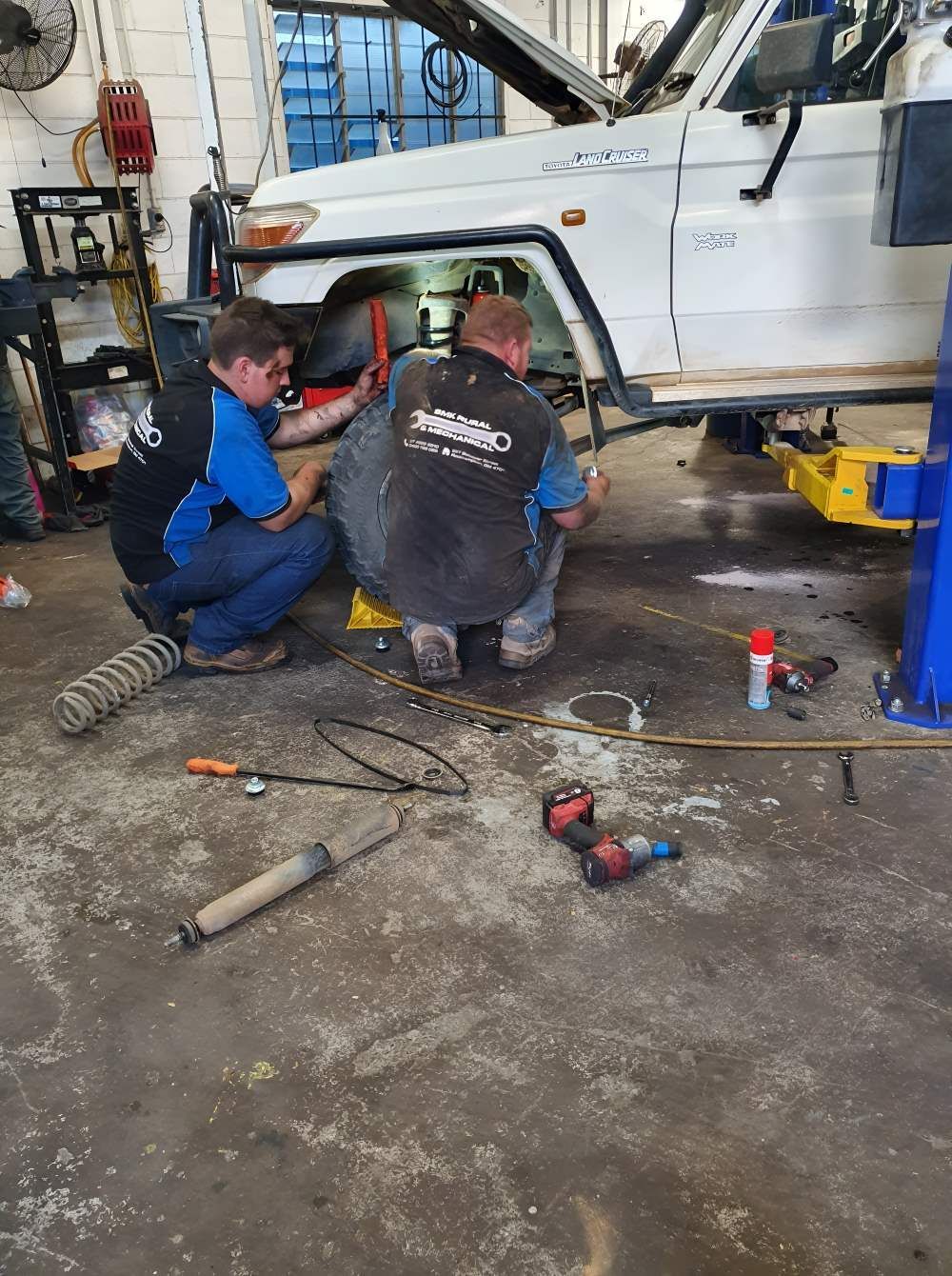 Two Men Are Working on a White Truck in a Garage — SMK Rural & Mechanical Pty Ltd in Rockhampton City, QLD