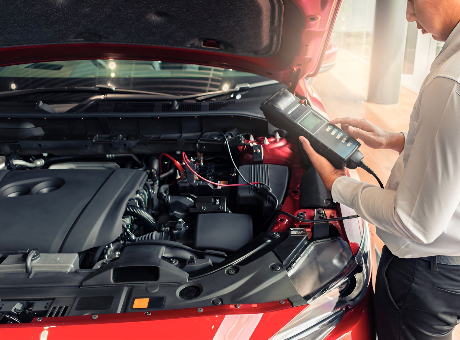 A Man is Working on the Engine of a Red Car — SMK Rural & Mechanical Pty Ltd in Rockhampton City, QLD
