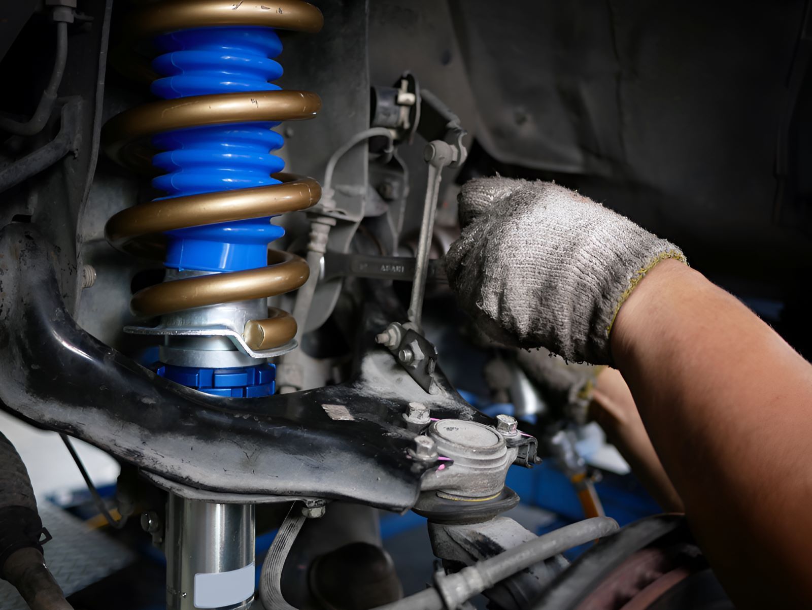 A Person is Working on a Car Suspension — SMK Rural & Mechanical Pty Ltd in Rockhampton City, QLD