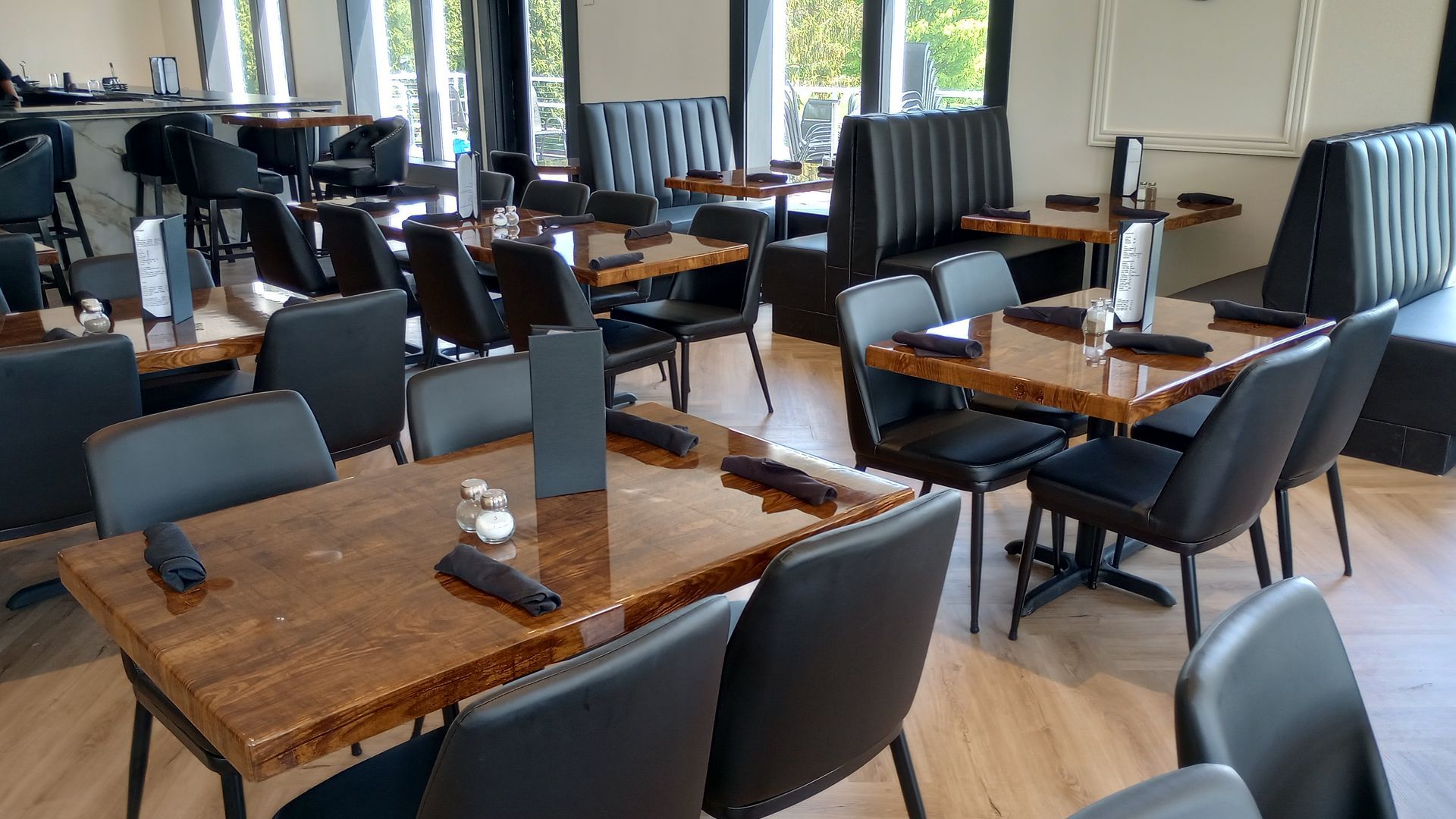 A restaurant filled with tables and chairs and a bar.