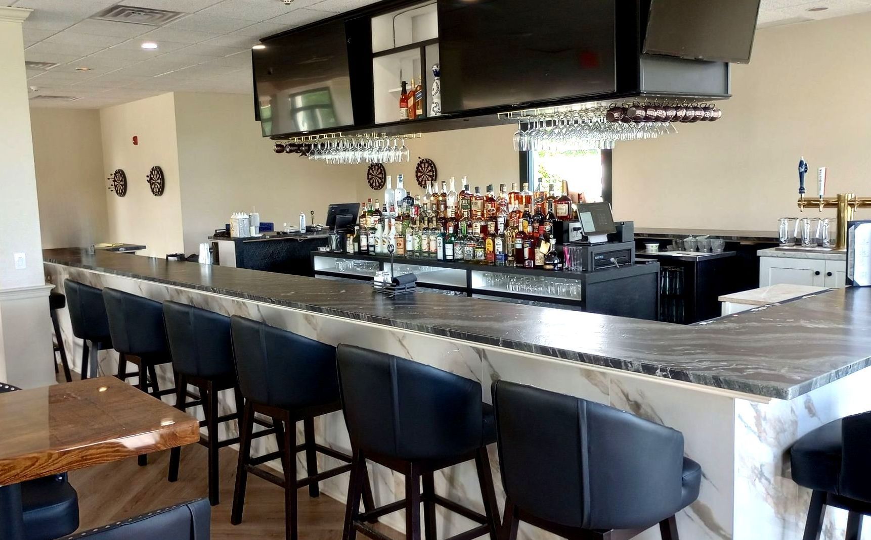 A long bar in a restaurant with a lot of alcohol on it.