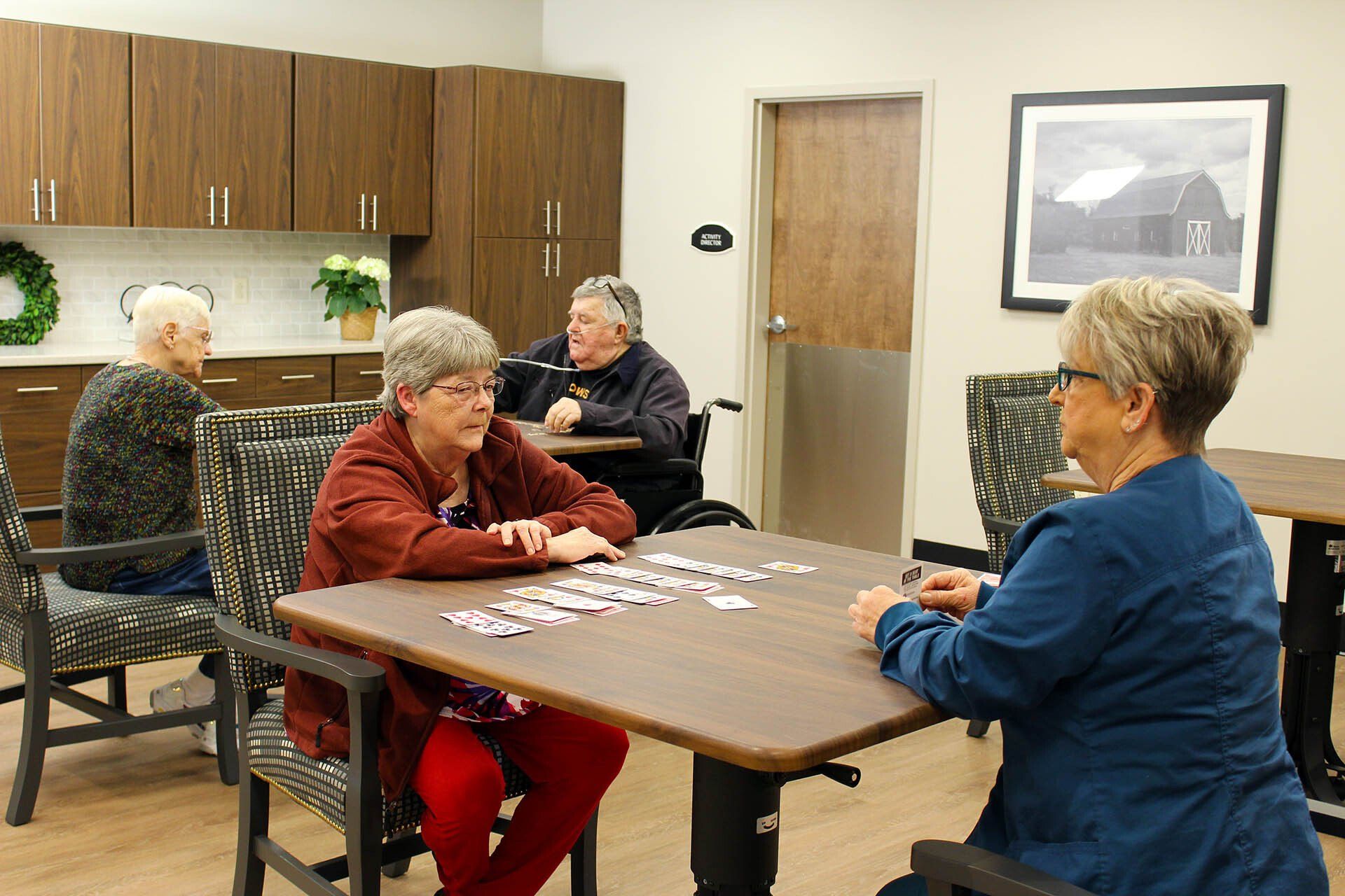 A group of elderly people are sitting around a table playing a game of puzzles.