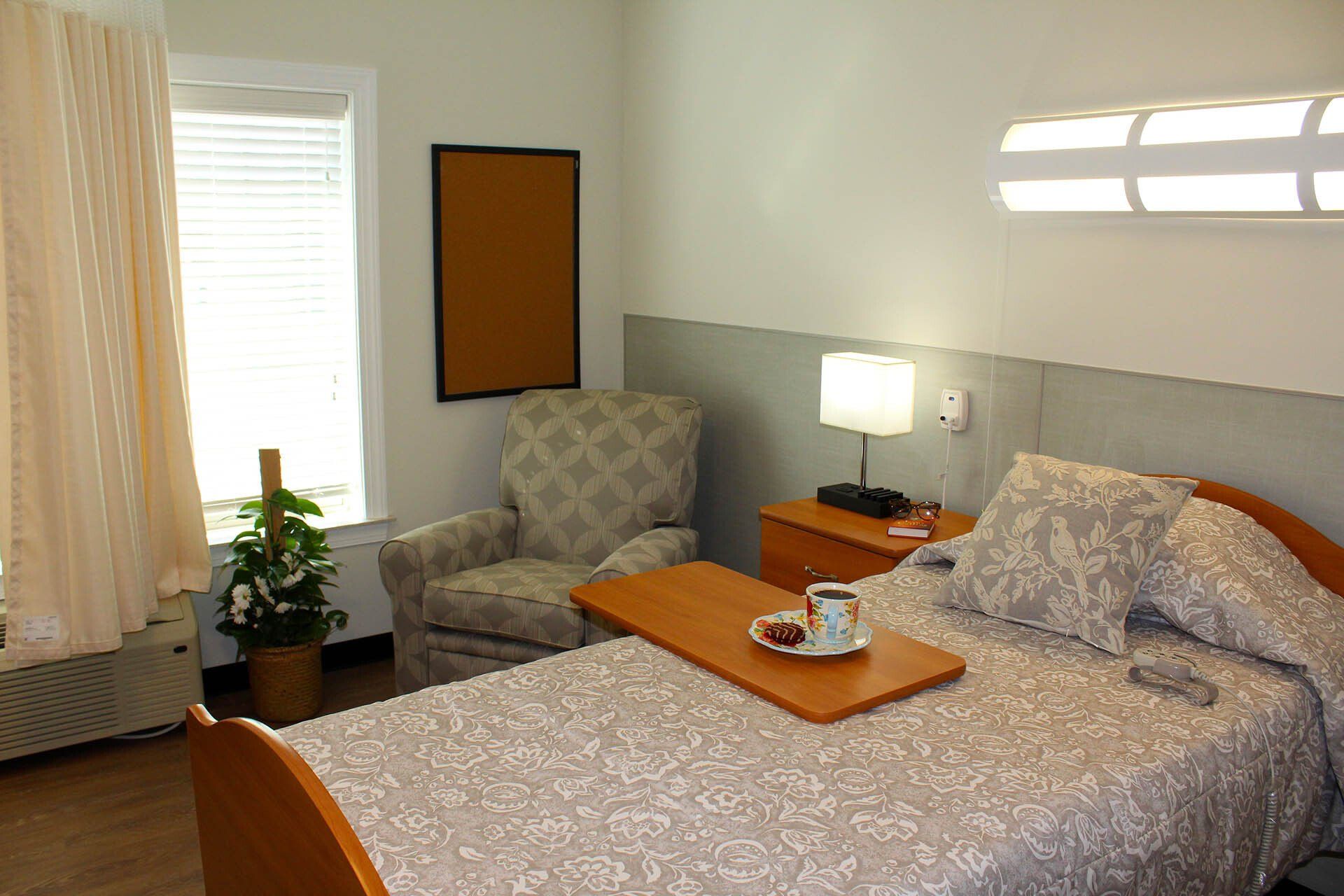 A bedroom with a bed a chair and a table