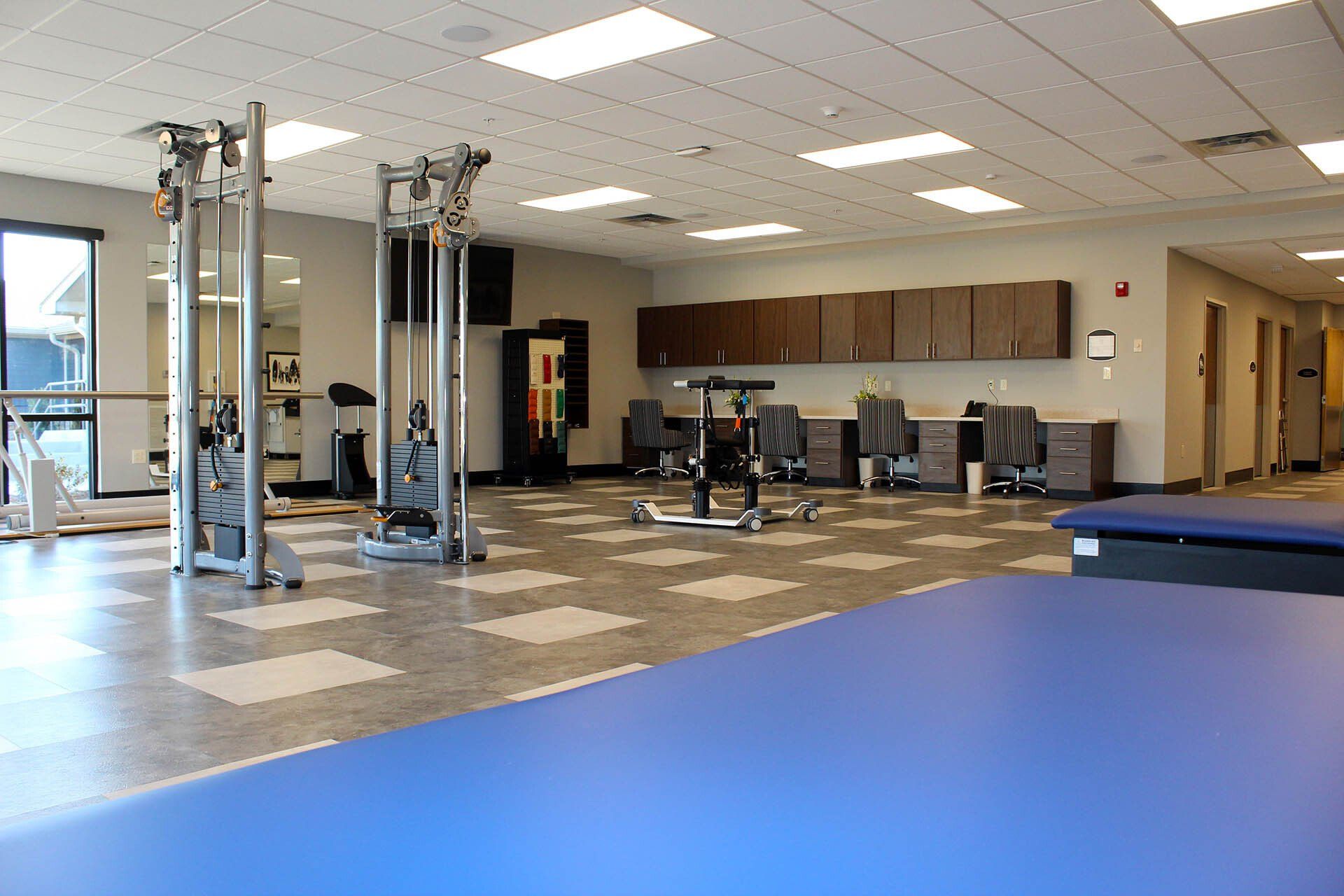 There is a blue mat in the middle of the gym.