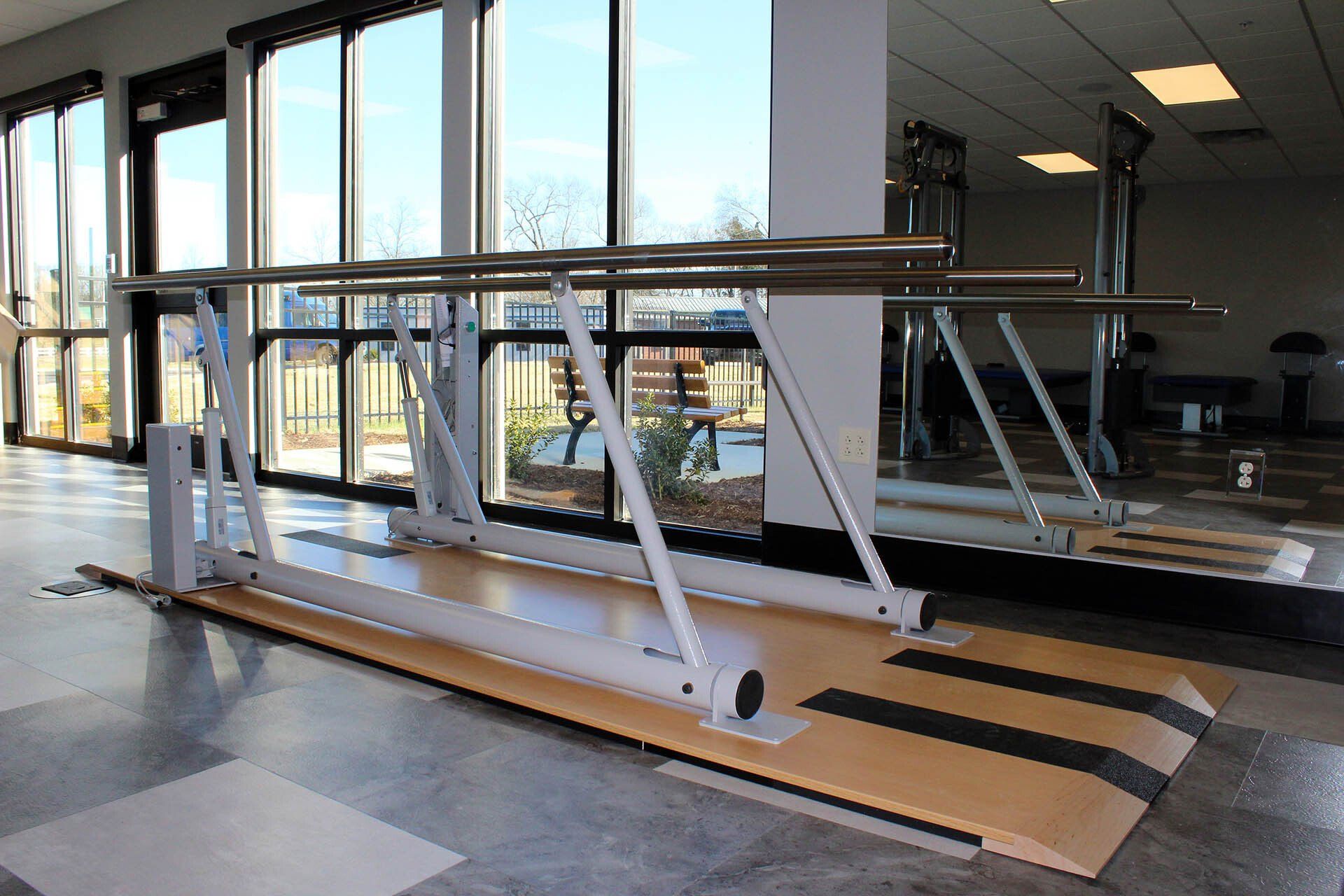 A pair of parallel bars in a room with lots of windows