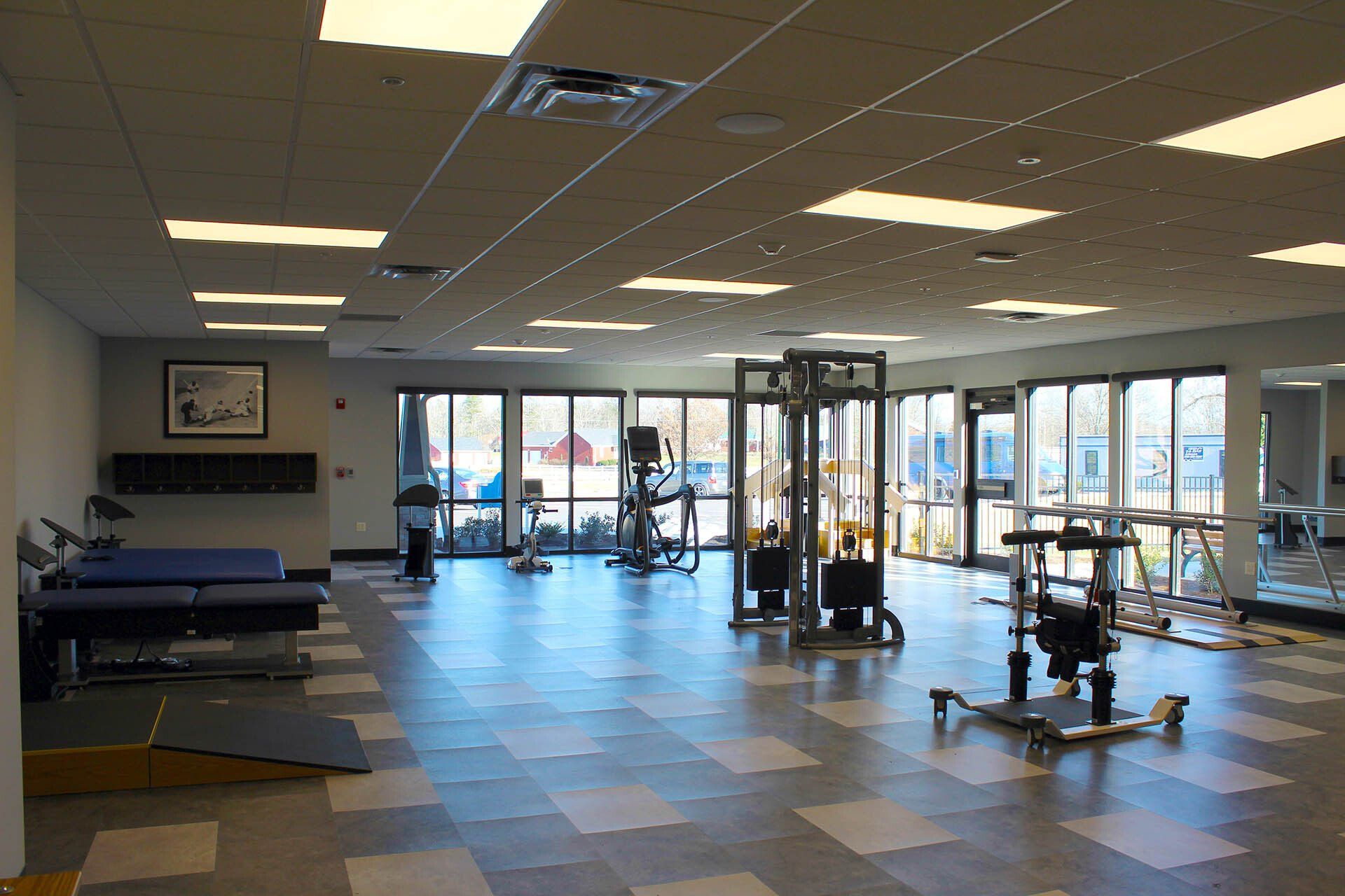 A large empty gym with a lot of exercise equipment.