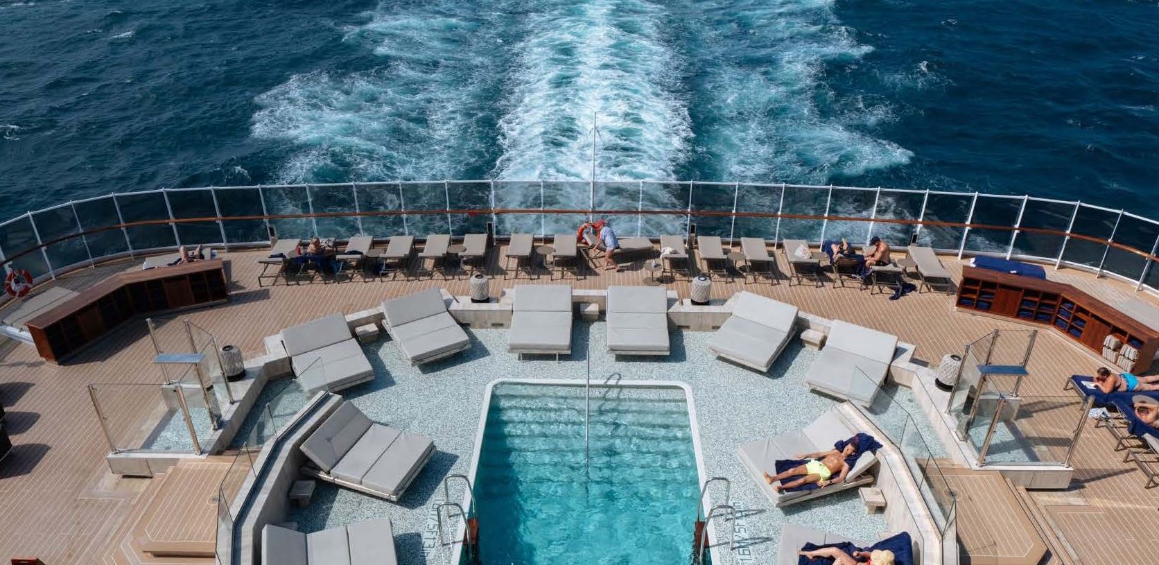 There is a large swimming pool on the deck of a cruise ship.