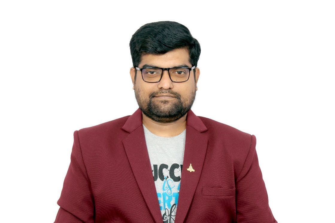 A man in a suit and tie is standing in front of a white background