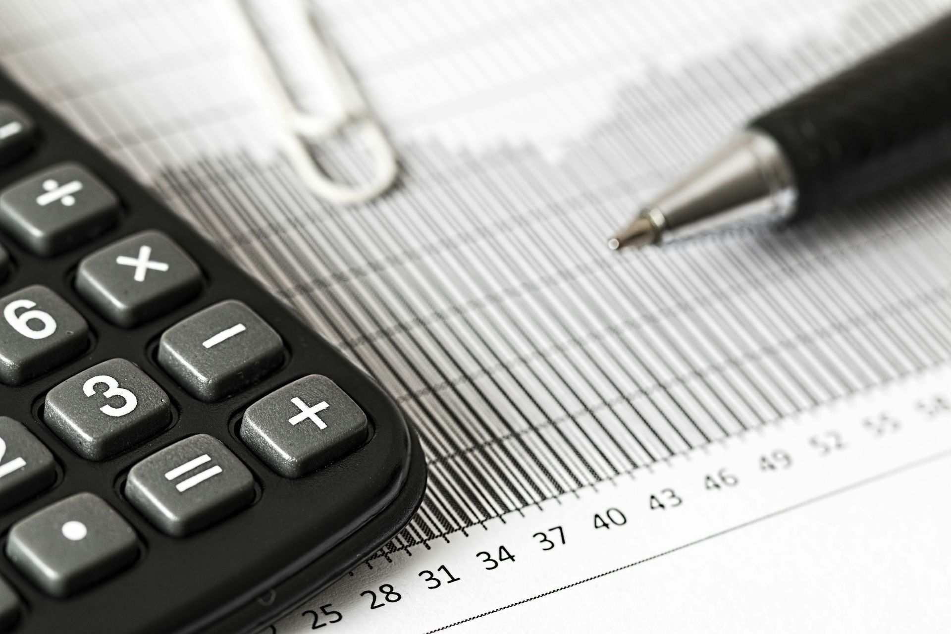 A calculator is sitting on top of a graph next to a pen