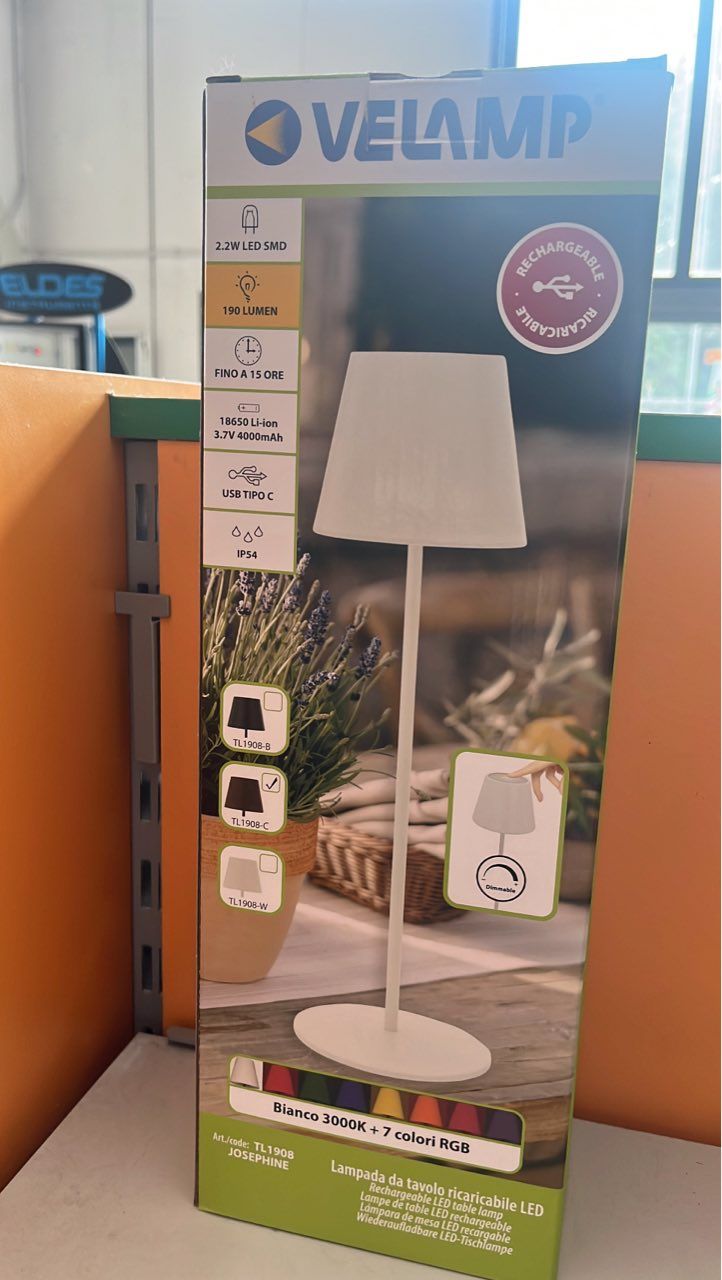 Scatola per lampada da esterno Velamp, bianca, con foto della lampada e di una scena di giardino.