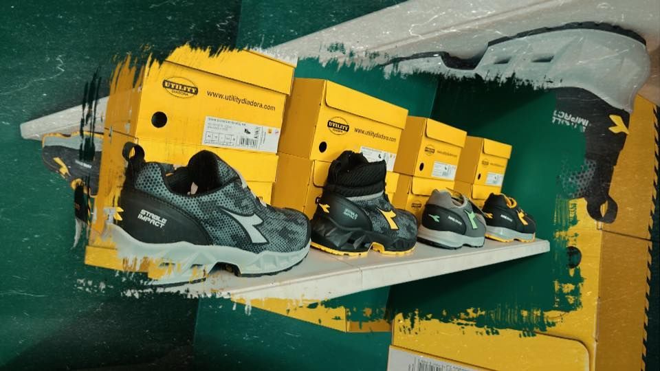 Scarpe su uno scaffale davanti a delle scatole, in un negozio con dettagli verdi e gialli.