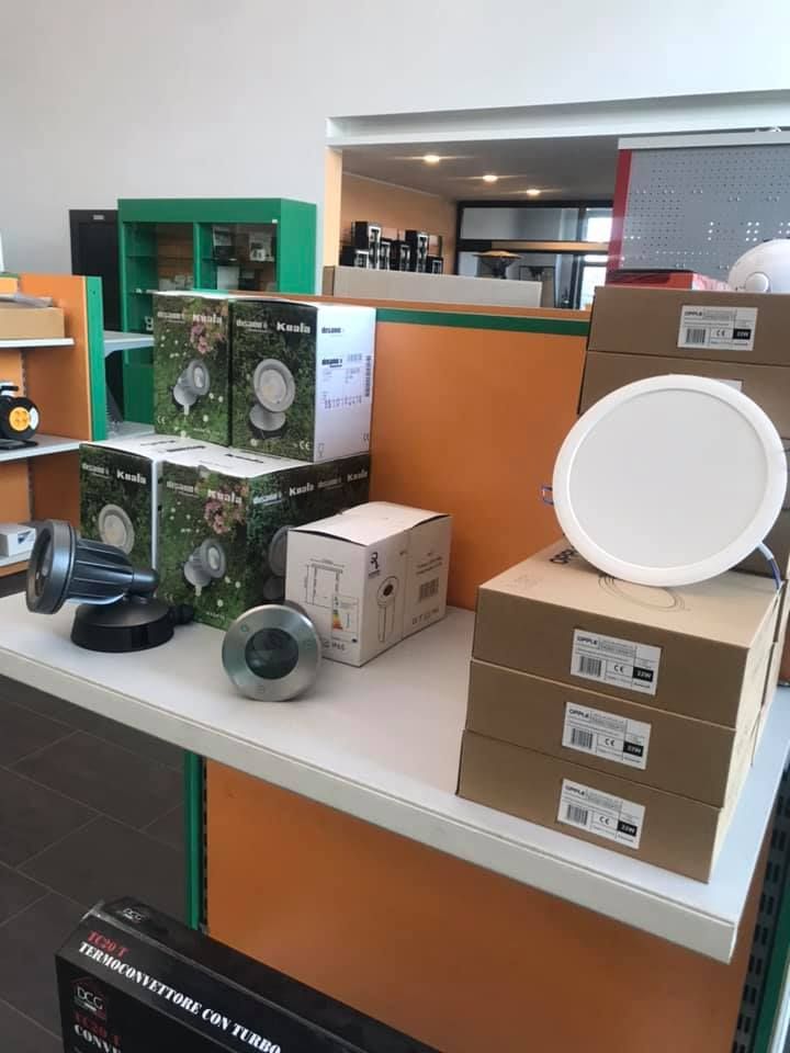 Esposizione di luci in scatola, tra cui faretti e faretti da incasso a soffitto, sul bancone di un negozio.