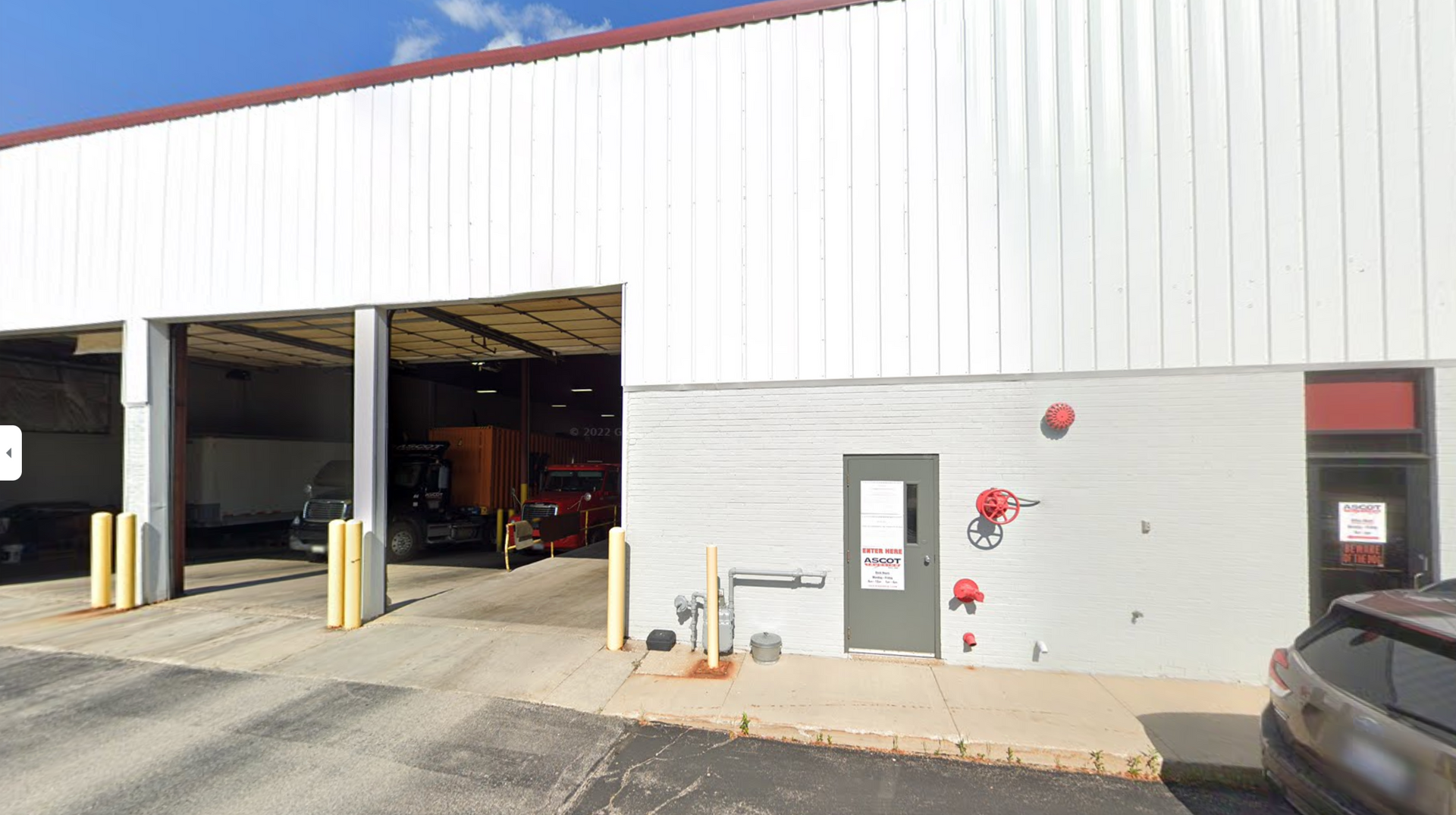 A white building with a lot of cars parked in front of it