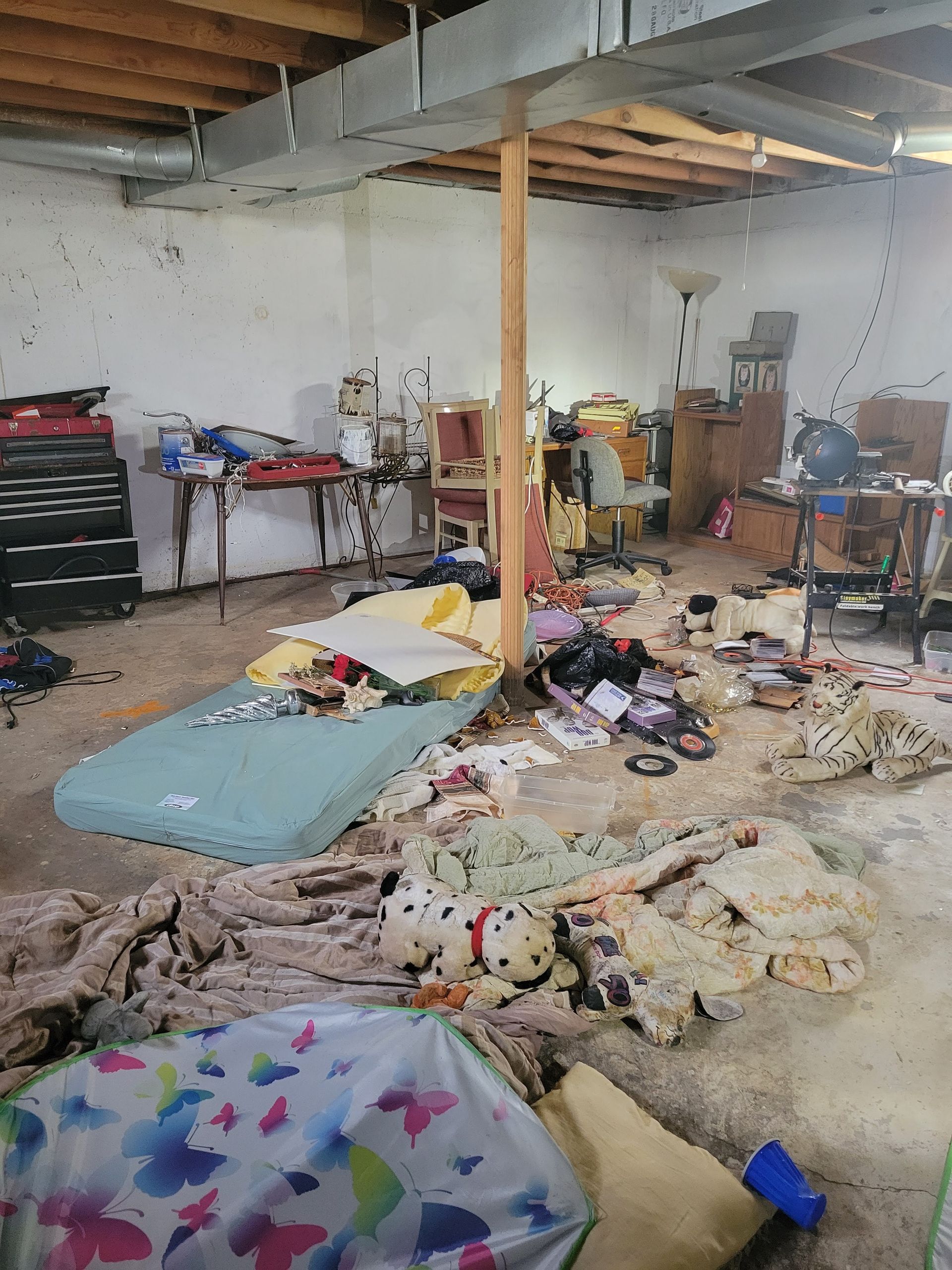 A messy room with a mattress on the floor.
