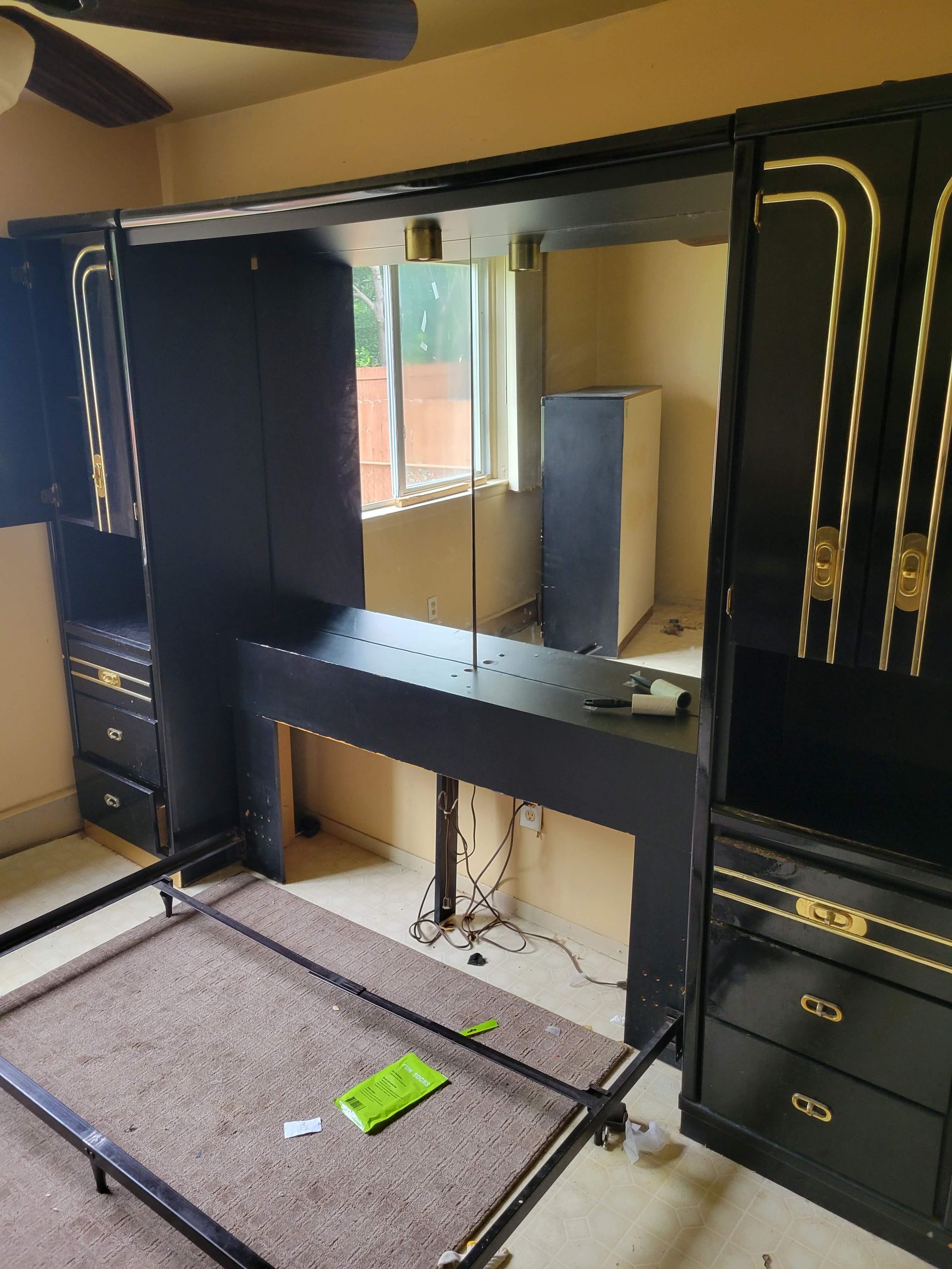A room with black cabinets and drawers and a ceiling fan
