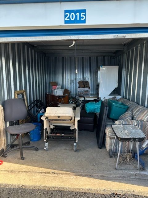 A woman is talking on a cell phone while holding a cup of coffee.