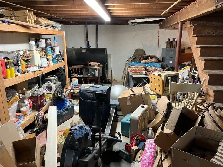 A cluttered basement filled with lots of boxes and furniture.