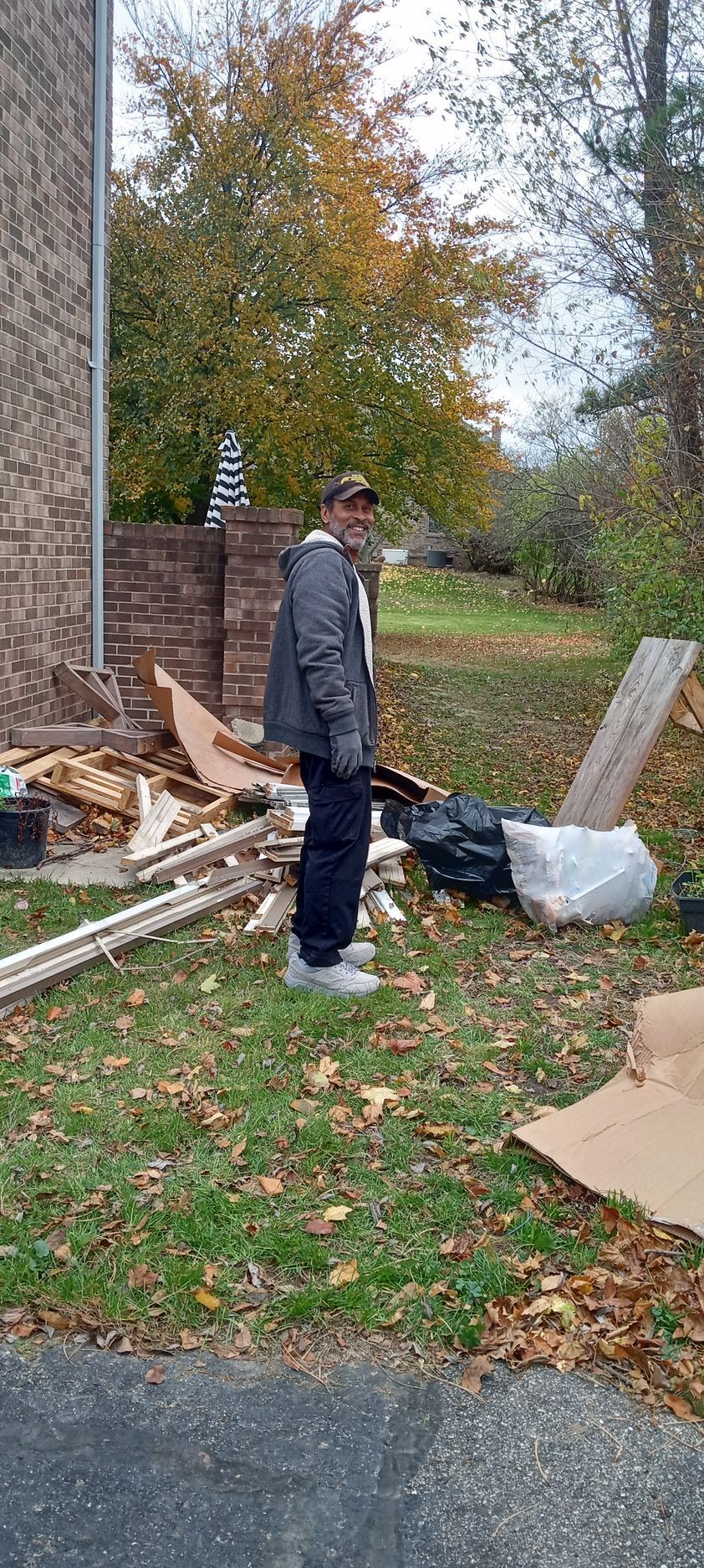 A man is standing in the grass in front of a house.