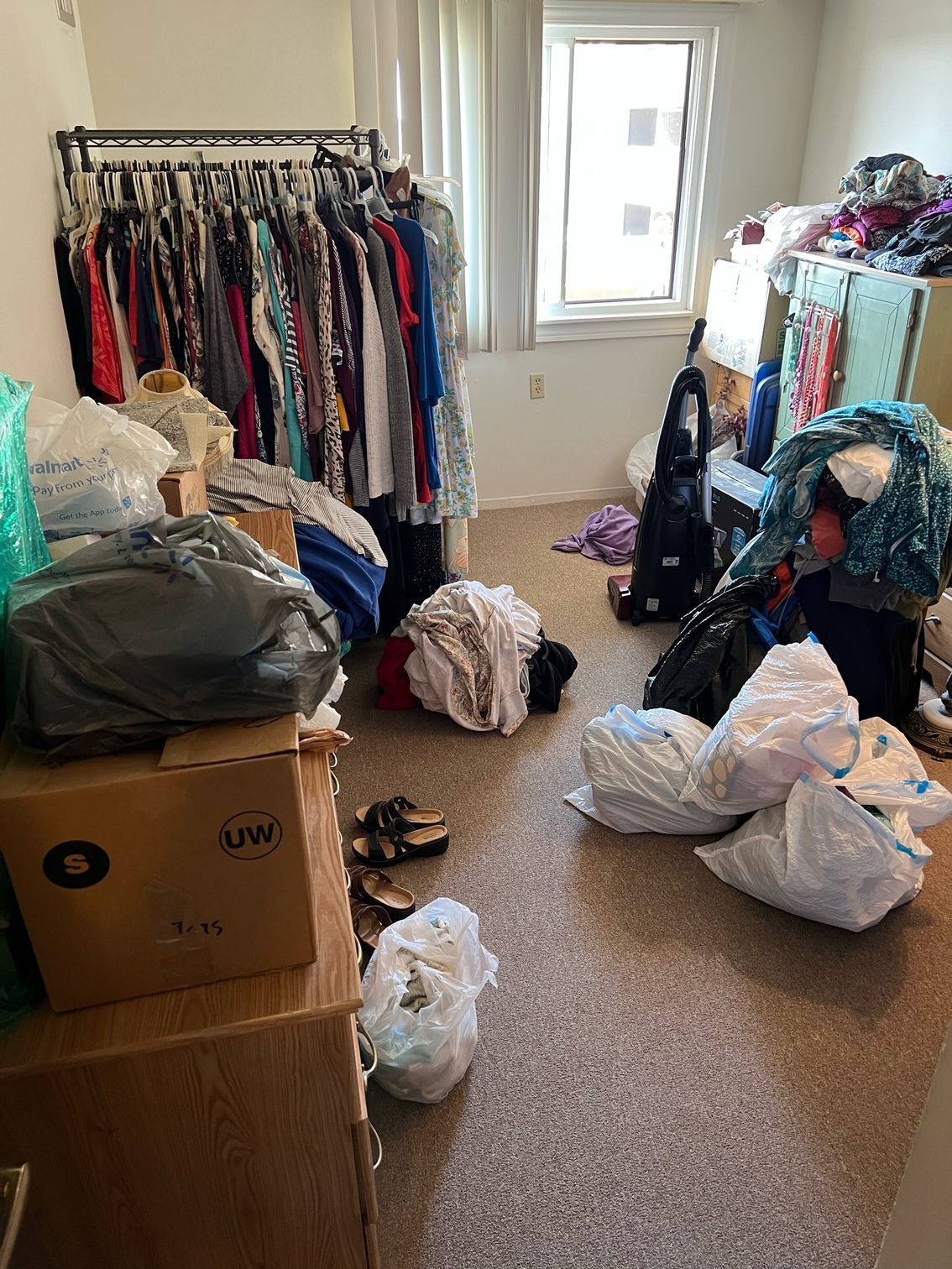 A room filled with lots of clothes and bags on the floor.