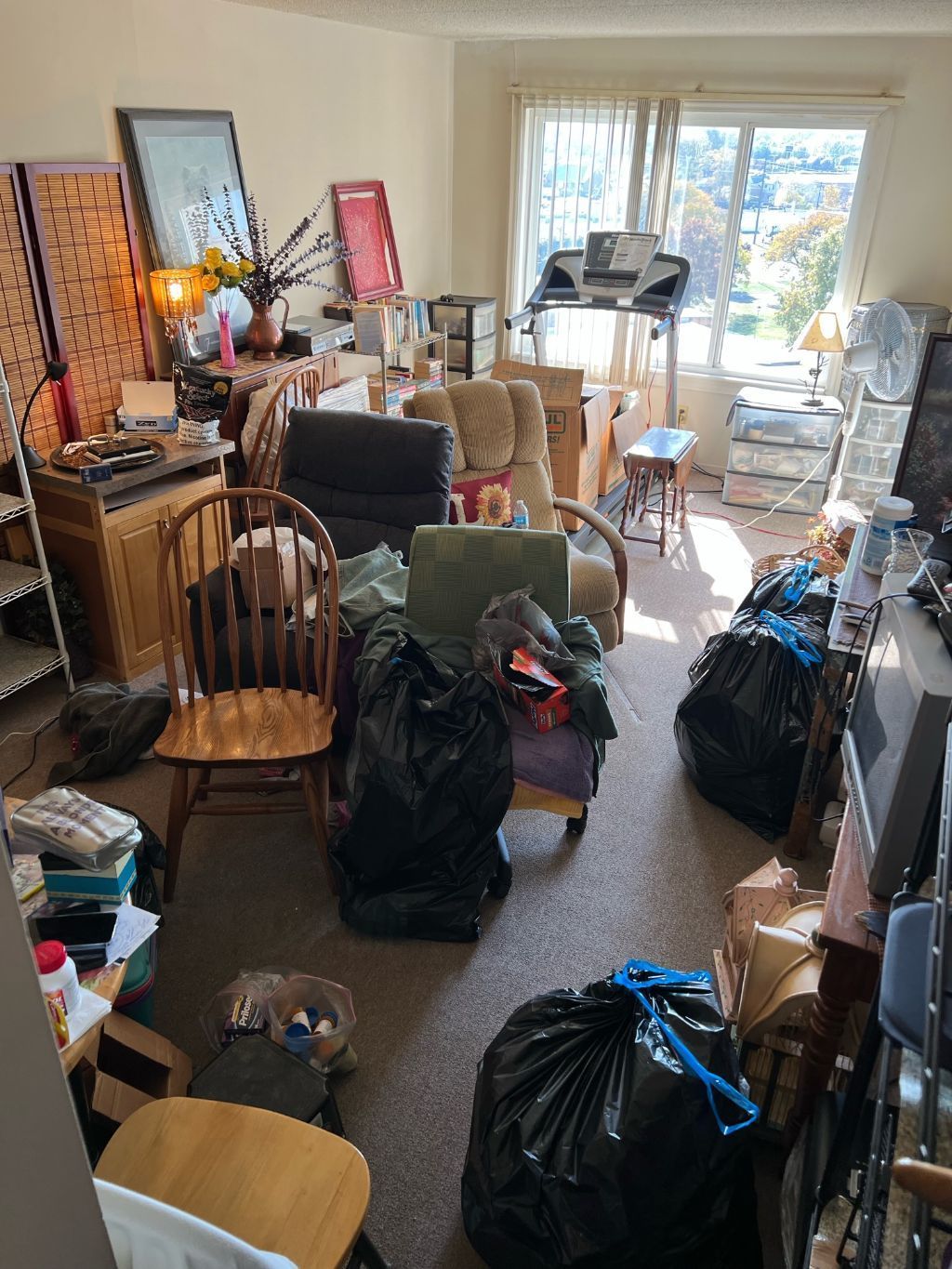 A living room filled with lots of furniture and trash bags.