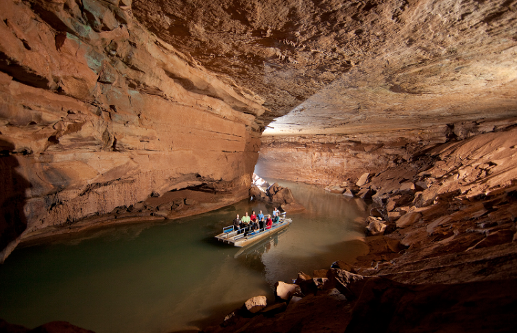 A group of people are riding a boat in a cave.