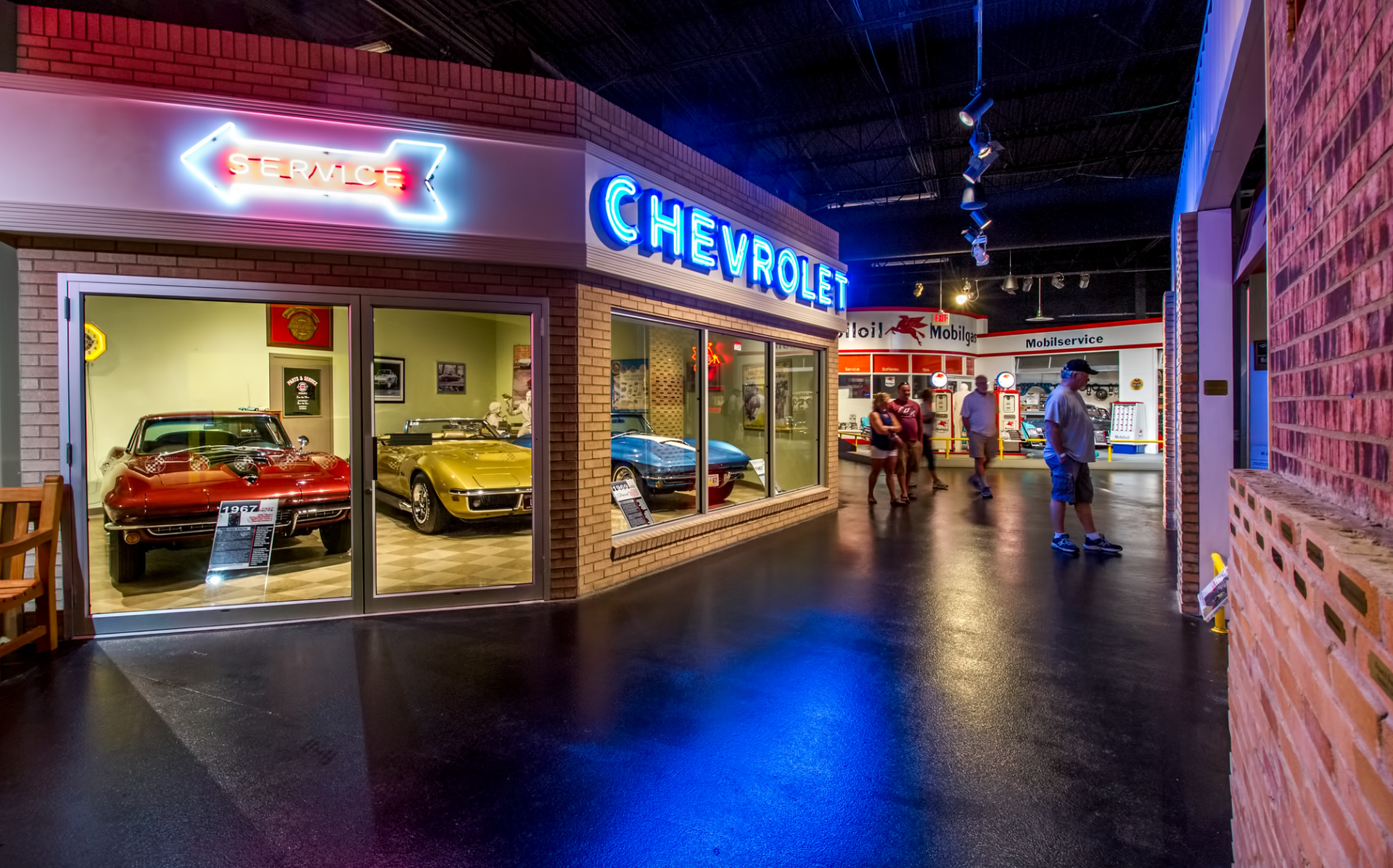 A group of people are standing in front of a chevrolet store.