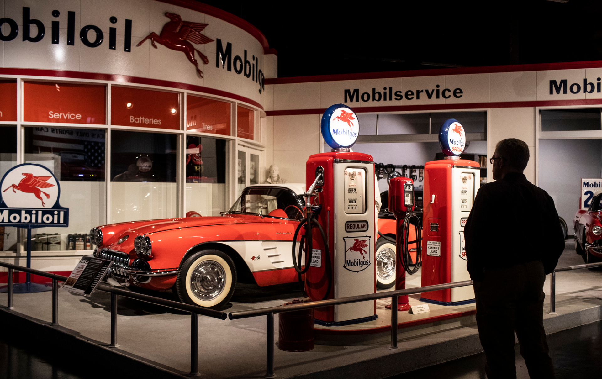 A man is standing in front of a mobil oil gas station