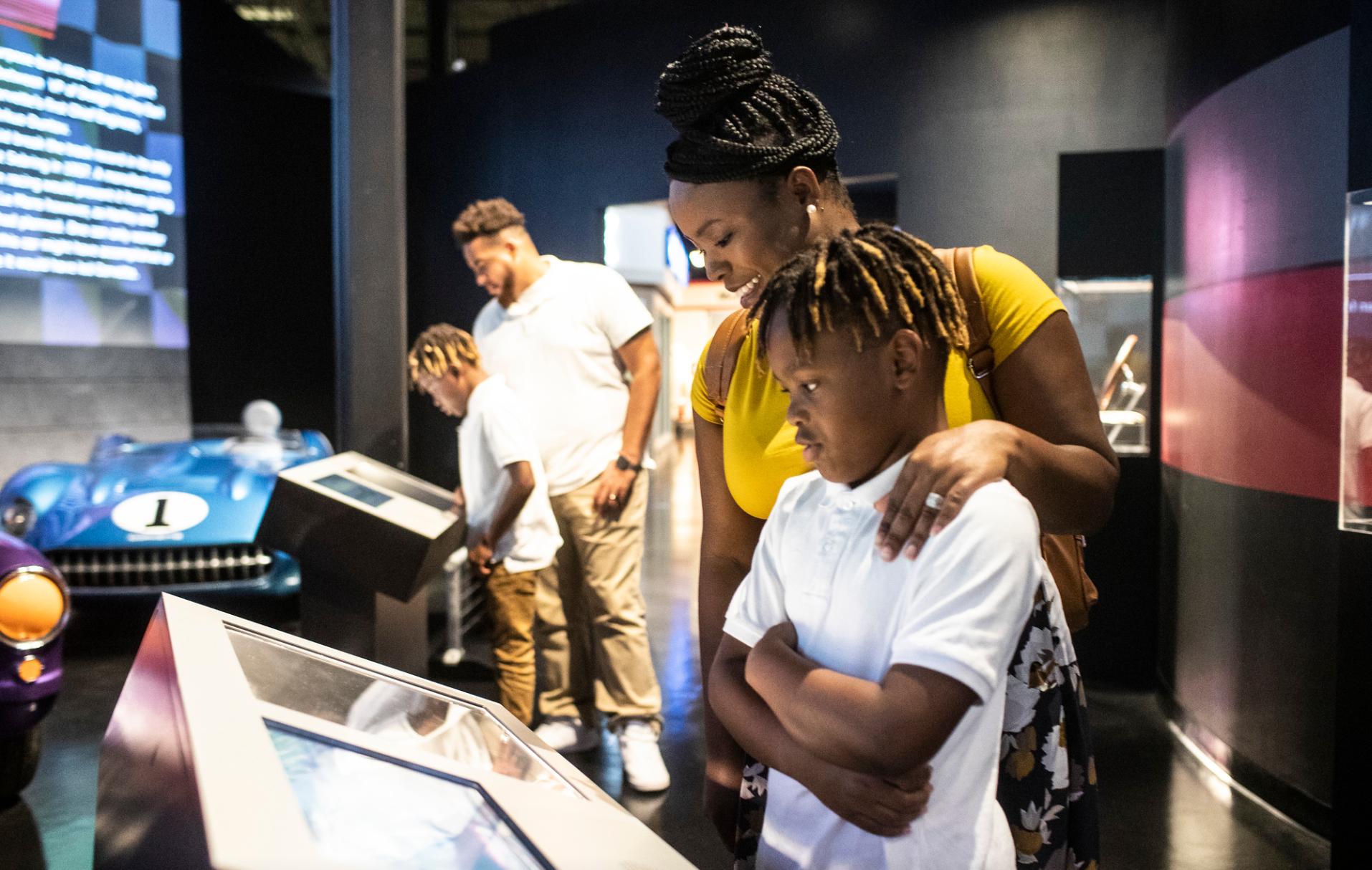A woman and a boy are looking at a display in a museum.