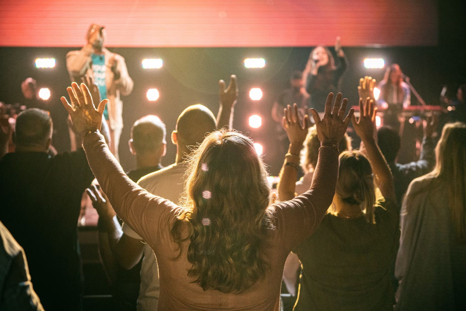 A group of people are sitting in a row holding bible and notebooks.