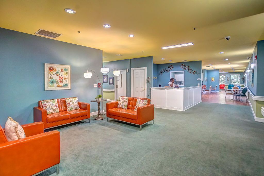 Lobby area with orange seating, turquoise walls, and a white reception desk.