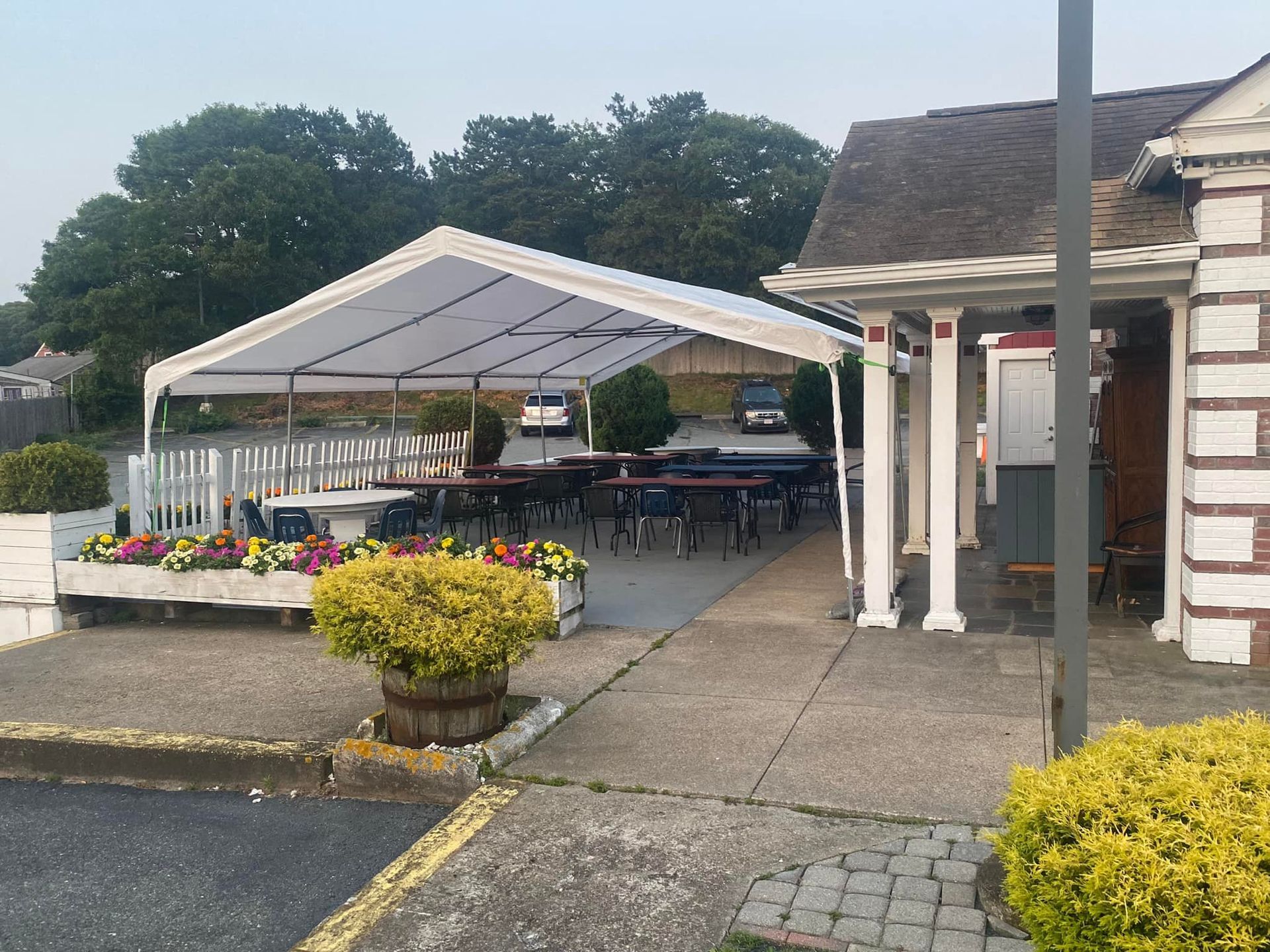 A white tent is sitting in front of a building