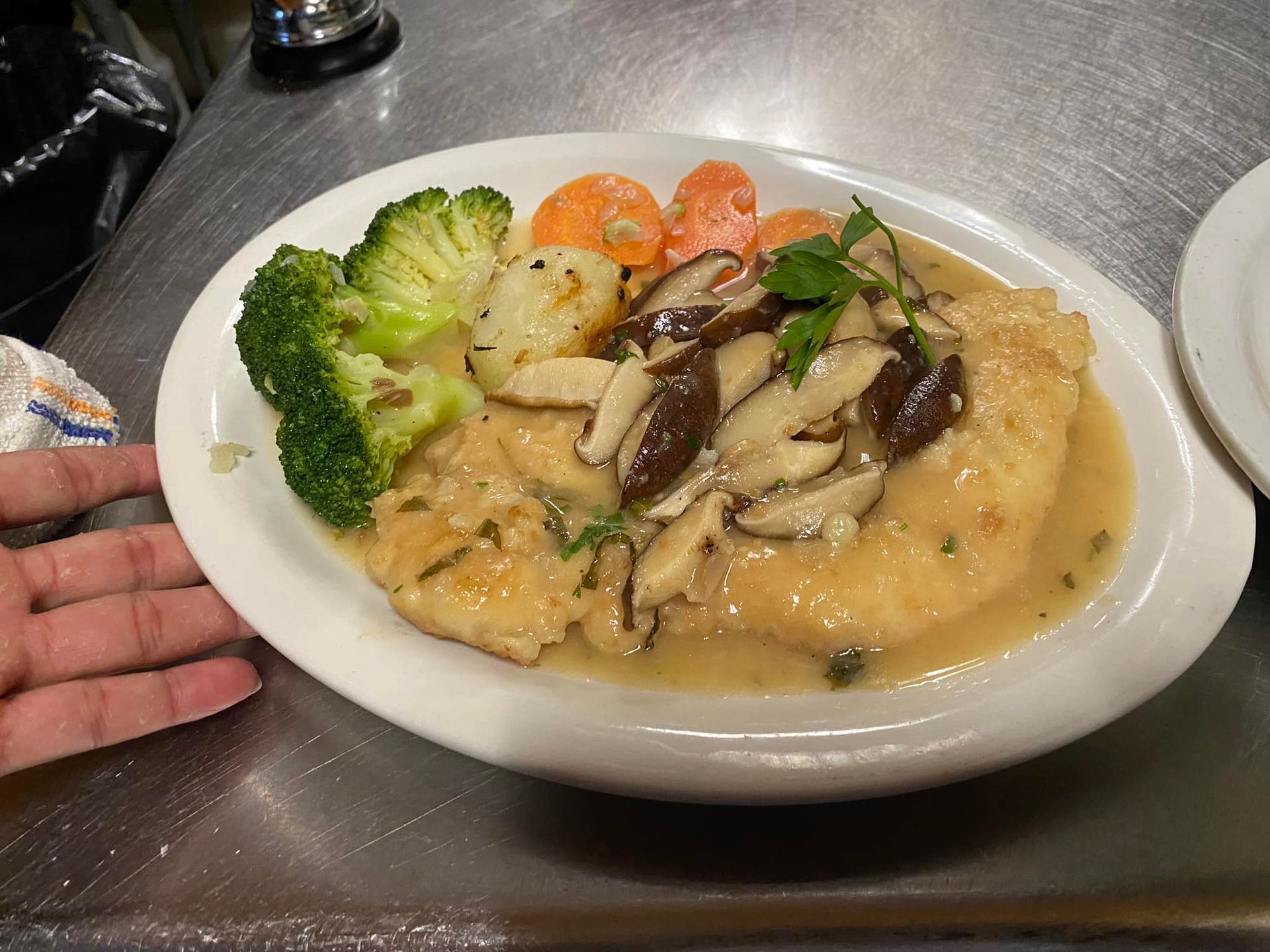 A plate of food with broccoli and mushrooms on a table.
