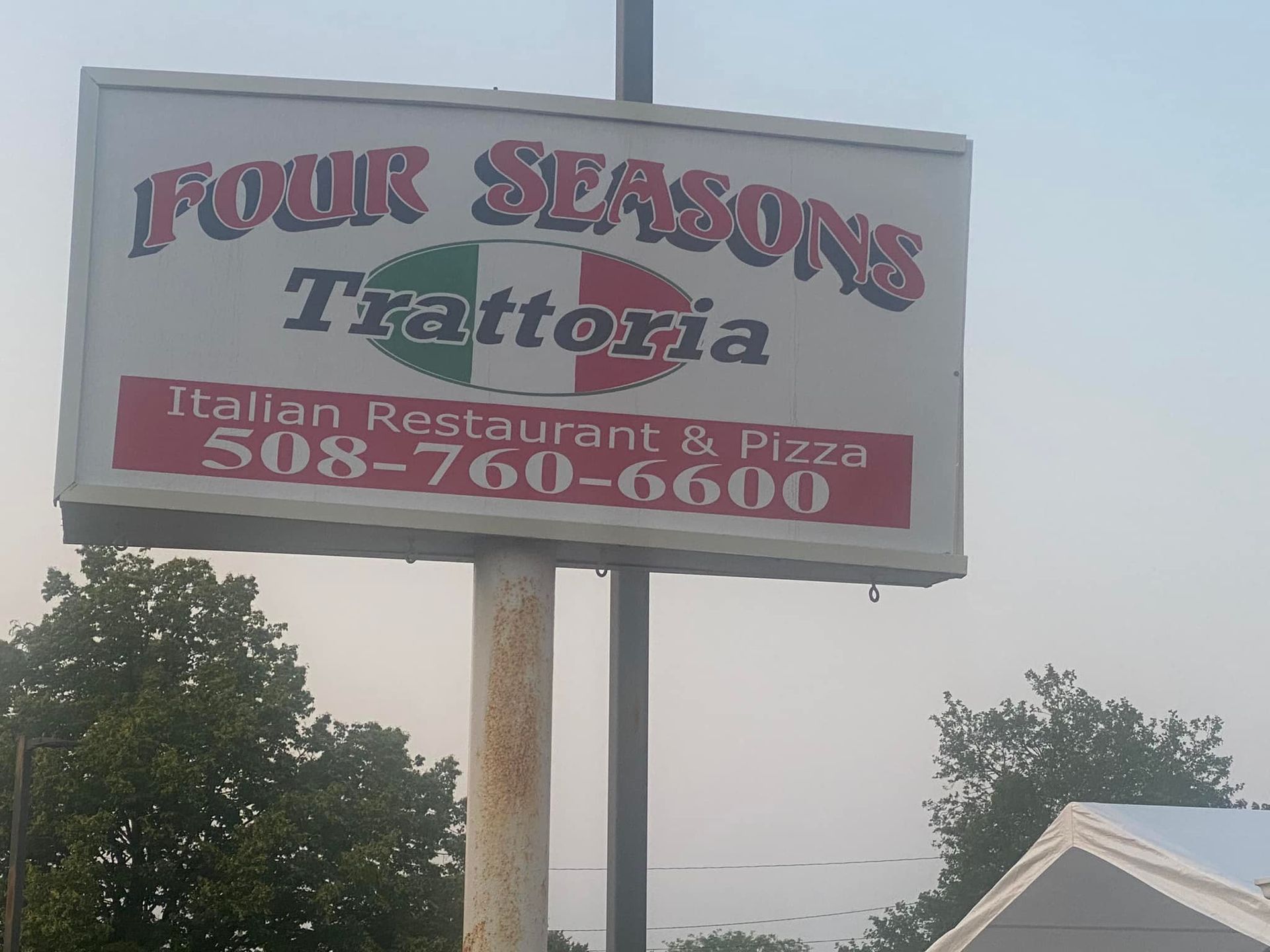A sign for four seasons trattoria italian restaurant and pizza
