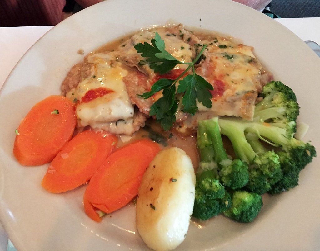 A plate of food with broccoli carrots and potatoes on a table