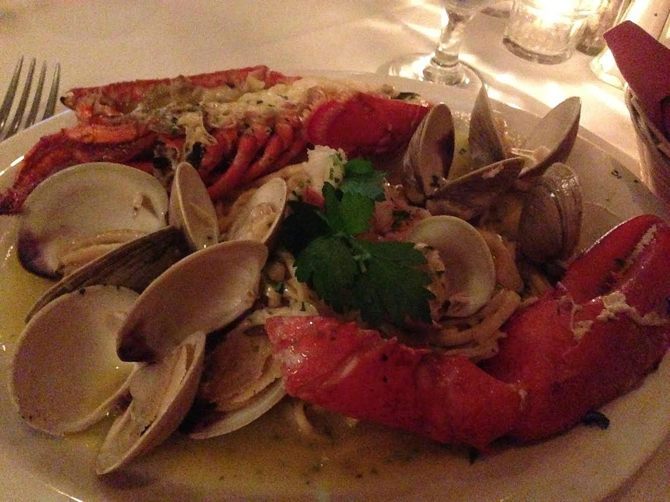 A plate of seafood including lobster clams and noodles