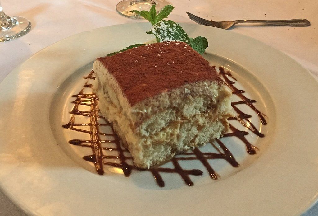 A white plate with a piece of cake on it