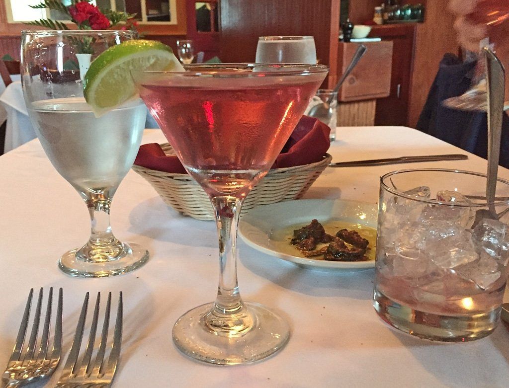 Two martini glasses on a table with a fork