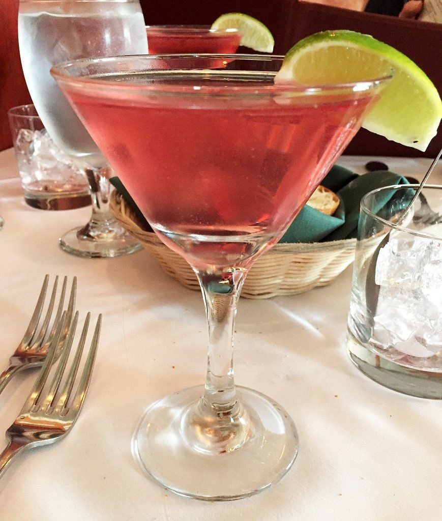 A martini glass with a slice of lime on top of it