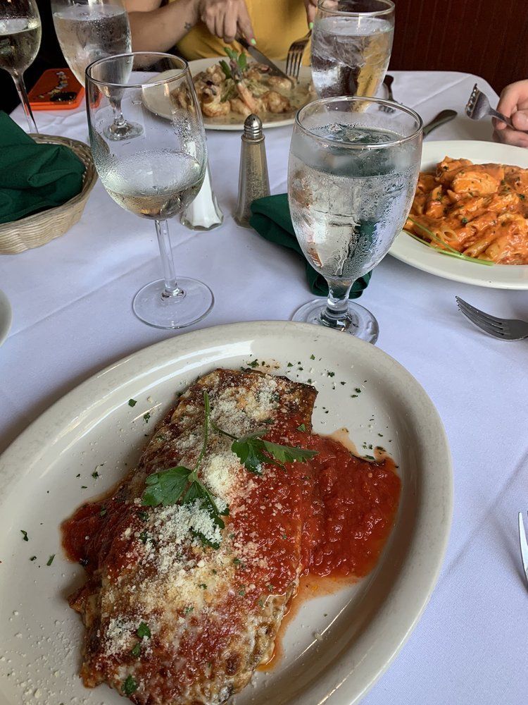 A plate of food is sitting on a table next to a glass of water.