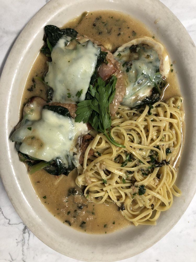 A plate of food with noodles and meat on a table.