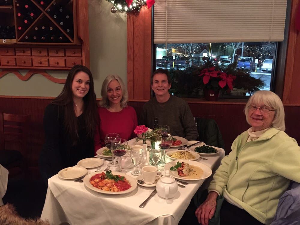 A group of people are sitting at a table with plates of food.