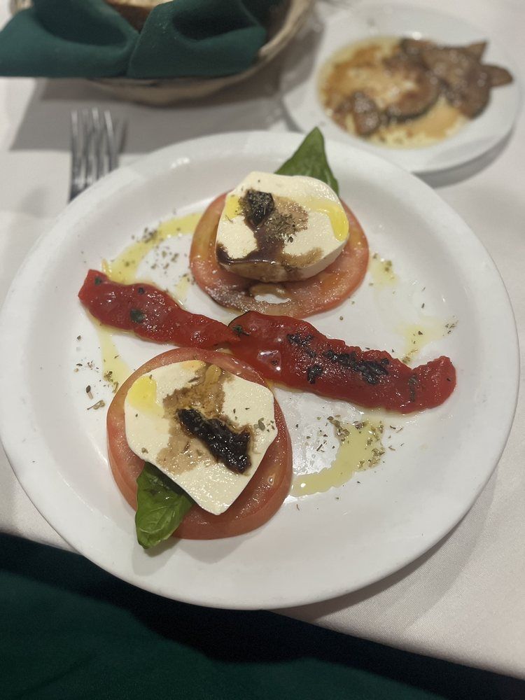 A plate of food with tomatoes and mozzarella on a table