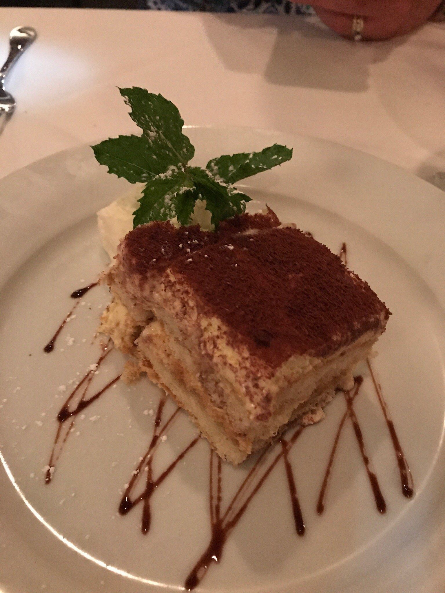 A white plate topped with a piece of tiramisu