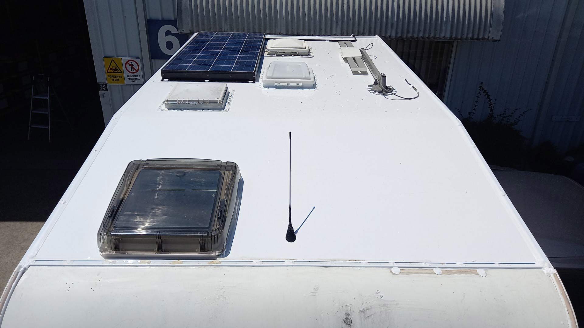 The Roof Of A Camper Van With Solar Panels And An Antenna On It — Lake Macquarie Caravan Repairs In Singleton, NSW